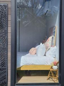 a display window of a bed with pillows on it at Deloraine Tiny Retreat in Whangarei
