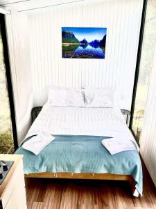 a bed in a bedroom with a large window at Aroha Tiny House in Rangihaeata