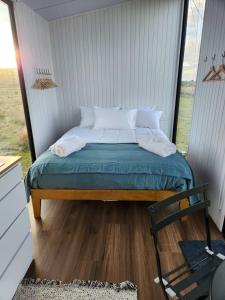 a bed in a small room with a window at Te Hau in Lower Dashwood