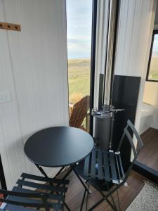 a table and chairs in a room with a window at Te Hau in Lower Dashwood
