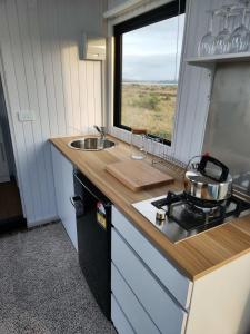 a kitchen with a stove and a sink and a window at Te Hau in Lower Dashwood