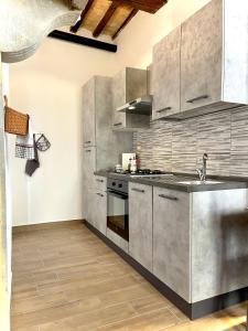 een keuken met roestvrijstalen apparatuur en houten vloeren bij L'Angoletto Home to Stay in Sansepolcro