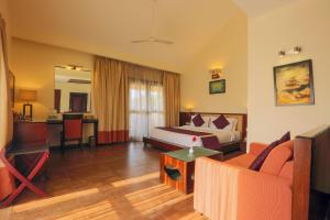 a hotel room with a bed and a couch at Resort De Coracao - Calangute , Goa in Calangute