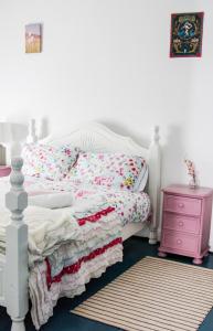 a bedroom with a white bed and a pink nightstand at Boss’s farmhouse in Valentia Island