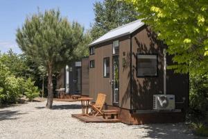 a brown tiny house with a table and a bench at Tiny Away Benger Garden 1 in Millers Flat