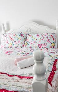 łóżko z kwiatowymi poduszkami i białą głową w obiekcie Boss’s farmhouse w mieście Valentia Island
