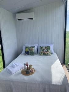 a white bed with a tray of food on it at The Coast 2 
