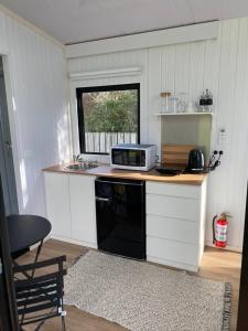 a kitchen with a microwave on a counter with a window at The Coast 2 
