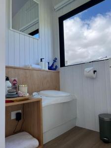 a bathroom with a bath tub and a window at The Coast 2 