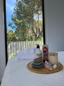 a tray with a bottle of soap and towels on a bed at The Coast 2 