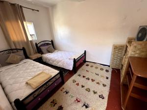 a bedroom with two bunk beds and a rug at Mabidi Surf Camp Morocco in Taghazout
