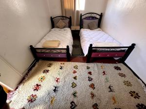 two twin beds in a room with a quilt at Mabidi Surf Camp Morocco in Taghazout