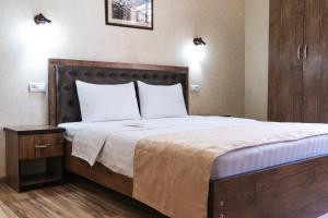 a bedroom with a large bed with a wooden headboard at TOURIST INN hotel in Tashkent