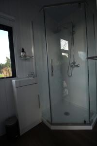 a bathroom with a glass shower and a sink at Breathe Inn in Kaitaia