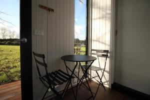 einen Tisch und zwei Stühle auf einer Veranda in der Unterkunft Breathe Inn in Kaitaia