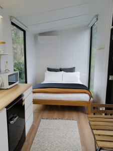 1 dormitorio con 1 cama y microondas en Creekside at Kuaotunu, en Matarangi