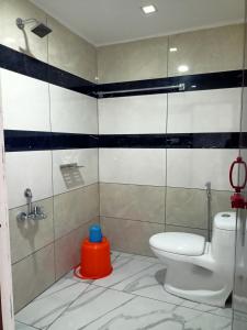 a bathroom with a toilet and a blue stool at Silver Munnar in Munnar