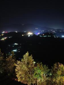 a view of a city at night with lights at Silver Munnar in Munnar