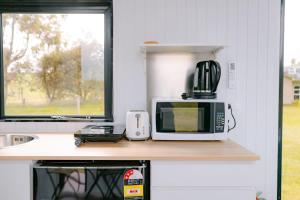 a microwave sitting on a counter next to a window at Harrington's on the Terrace - Luxmore in Te Anau