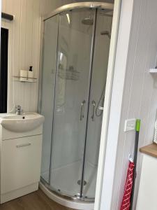 ein Bad mit einer Dusche und einem Waschbecken in der Unterkunft Cosy Dell in Herbert