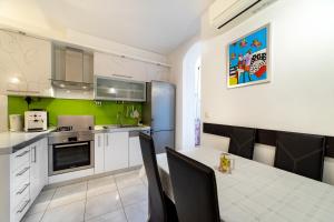 een keuken met witte kasten en een tafel met stoelen bij Apartment Happy in Split center 10 min walk from Bačvice beach in Split