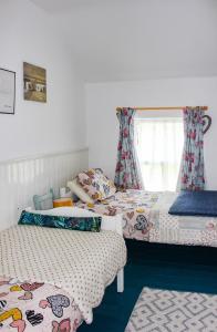 a bedroom with two beds and a window at Boss’s farmhouse in Valentia Island
