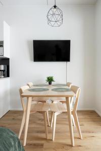 a dining room table with chairs and a tv at Studio Brita in Helsinki