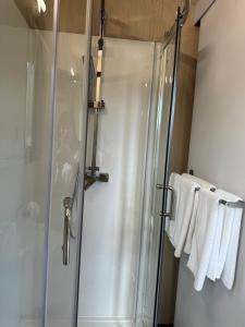 um chuveiro com uma porta de vidro e toalhas na casa de banho em Sweet Hart 2 em Tamahere