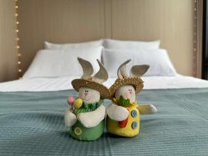 duas figuras de duas pessoas usando chapéus em uma cama em Sweet Hart 2 em Tamahere