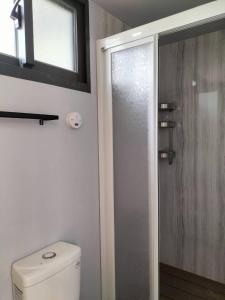 a bathroom with a toilet and a glass shower door at The Dawn 2 in Kaohsiung