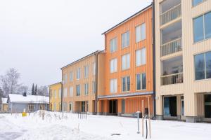 uma fila de edifícios com neve à frente deles em Studio Brita em Helsínquia