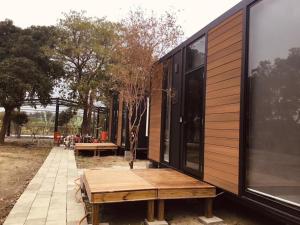 una casa con una mesa de madera en un lateral en Gandan Inn en Douliu