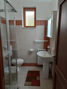 uma casa de banho com um WC, um lavatório e um chuveiro em Masseria Marciane em Uggiano la Chiesa