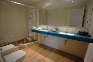 a bathroom with a toilet and a sink and a mirror at Buil & Gine Wine Hotel in Gratallops