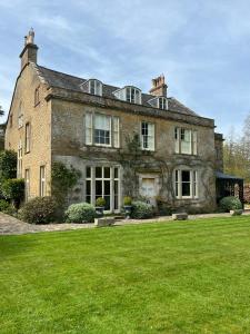 uma grande casa de tijolos com um grande jardim de relva em The Old Rectory Somerset em North Perrott