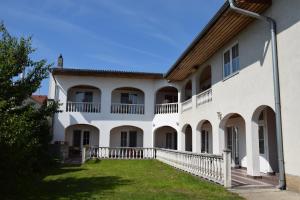 a large white building with balconies and a yard at Appartmenthaus Rosenhof in Podersdorf am See