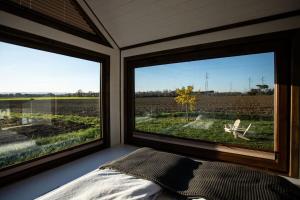 阿雷佐的住宿－Dolce Casa 1，一间卧室设有两个大窗户,享有田野美景