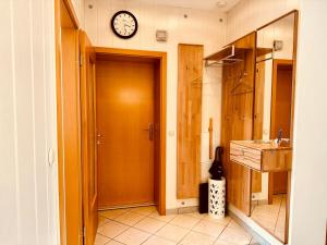 uma casa de banho com um lavatório e um relógio na parede em Ferienwohnung Haus Feig em Geyer