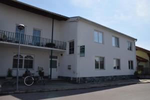 ein weißes Gebäude mit einem Fahrrad davor in der Unterkunft Appartmenthaus Rosenhof in Podersdorf am See