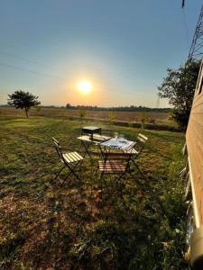 a table and chairs in a field with the sunset at Dolce Casa 2 in Arezzo