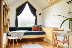 ein Zimmer mit einer Bank in einem winzigen Haus in der Unterkunft Bostebacken Gard Tiny House in Eckerud