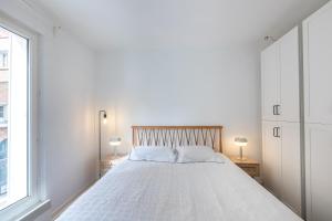 - une chambre blanche avec un grand lit et deux lampes dans l'établissement Appartement cosy et équipé proche paris, à Le Pré-Saint-Gervais
