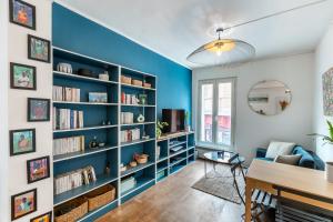 un salon avec un mur bleu et des étagères dans l'établissement Appartement cosy et équipé proche paris, à Le Pré-Saint-Gervais