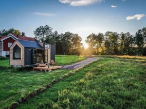 a small cabin in the middle of a grassy field at Bostebacken Gard Tiny House in Eckerud