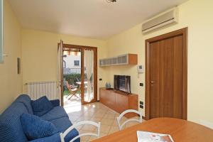 een woonkamer met een blauwe bank en een tafel bij Borgo delle Colline 19 by Wonderful Italy in Manerba del Garda