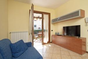 een woonkamer met een blauwe bank en een tv bij Borgo delle Colline 19 by Wonderful Italy in Manerba del Garda
