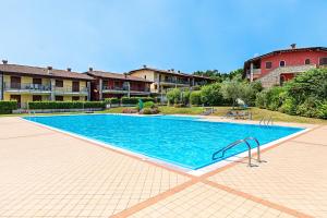 een groot zwembad in een tuin met huizen bij Borgo delle Colline 19 by Wonderful Italy in Manerba del Garda