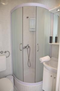 een badkamer met een douche, toilet en wastafel bij Rooms Kresan in Zadar