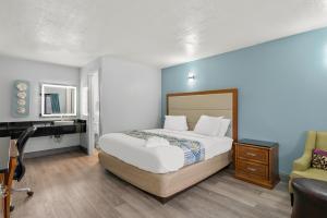1 dormitorio con cama, escritorio y ordenador en Americas Best Value Inn Bangor en Bangor