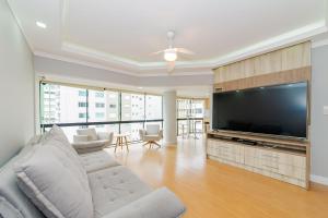 uma sala de estar com uma grande televisão de ecrã plano em Amplo Apto 2sui+1Q Vista Mar 50m da Praia em Balneário Camboriú